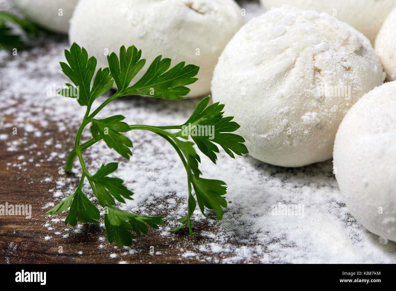 Khinkali on wooden plate with flour. Pelmeni. Stock Photo