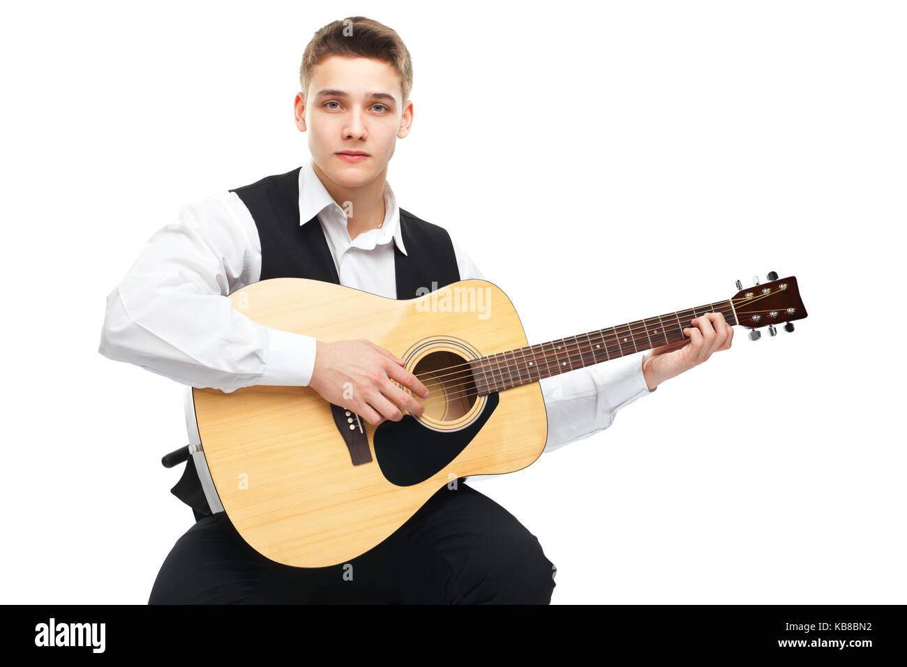 Young man playing on acoustic guitar sitting on a chair isolated on ...