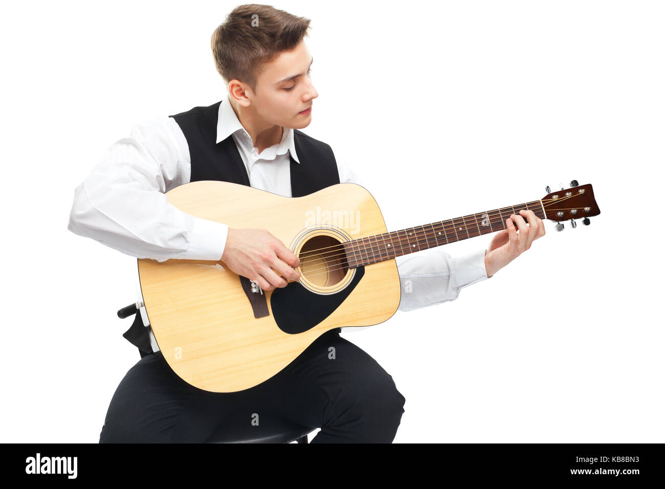 Young man playing on acoustic guitar sitting on a chair isolated on ...