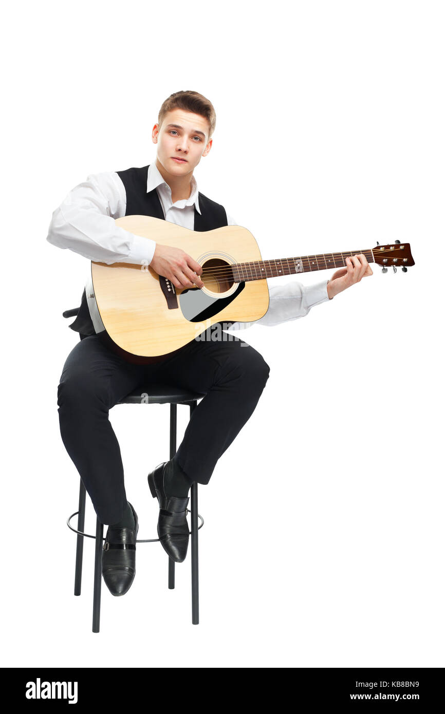 Young man playing on acoustic guitar sitting on a chair isolated on ...