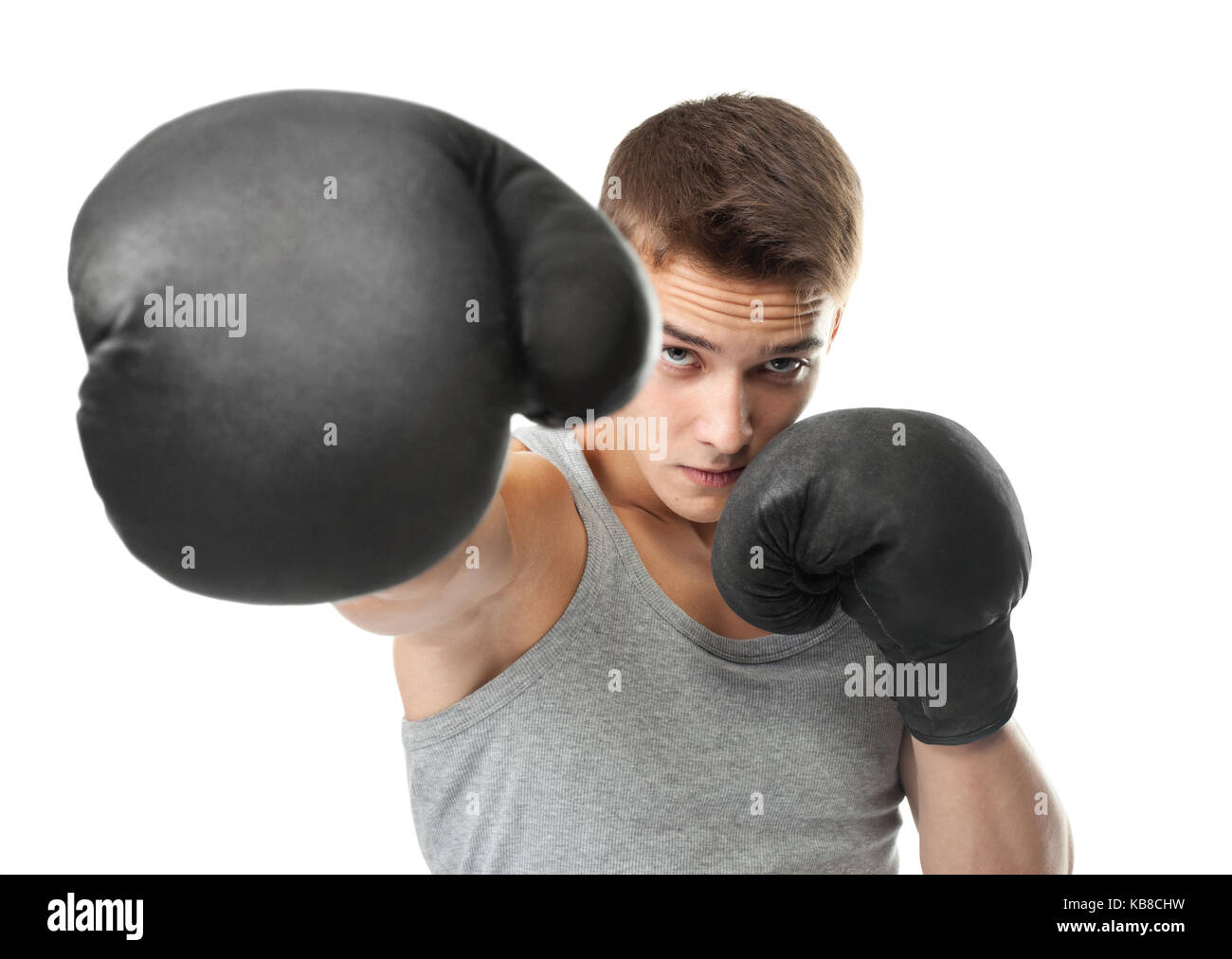 Portrait of young boxer throwing a punch at the camera isolated on