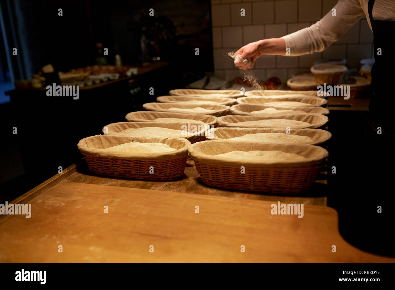 baker with baskets for dough rising at bakery Stock Photo Alamy