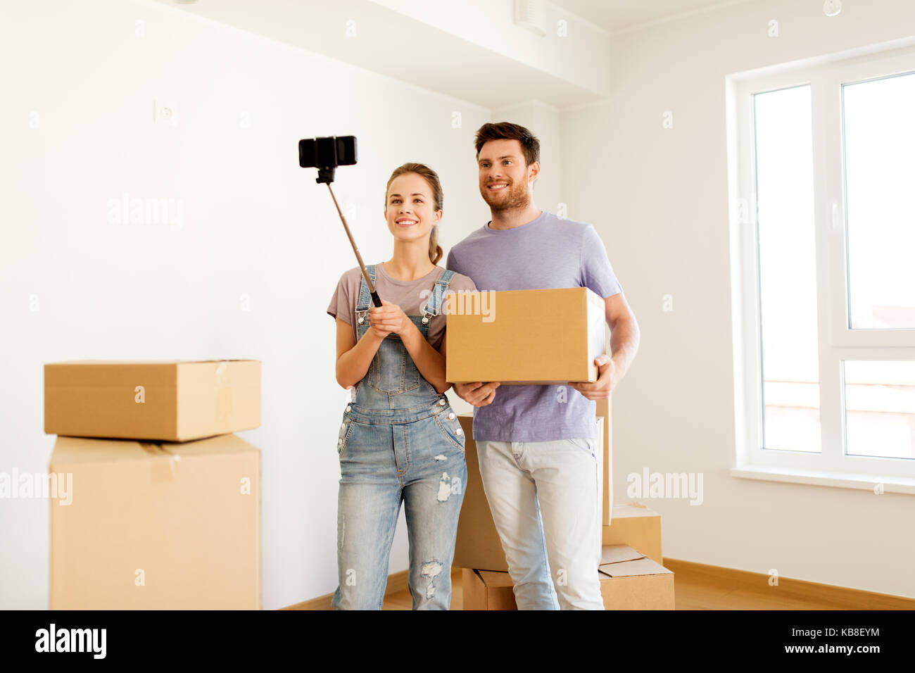 happy couple with boxes moving to new home Stock Photo - Alamy