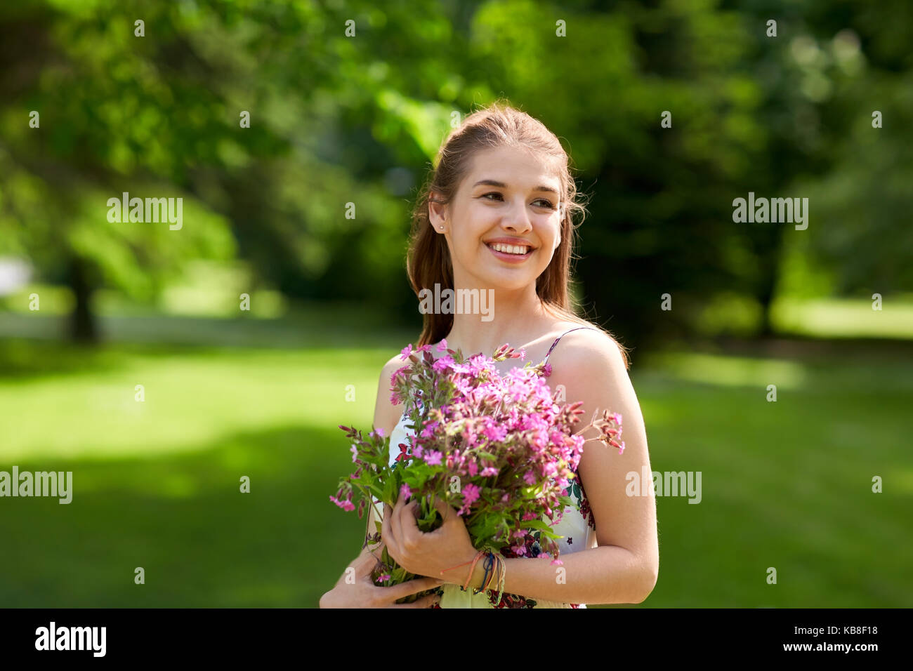 happy young woman with flowers in summer park Stock Photo - Alamy