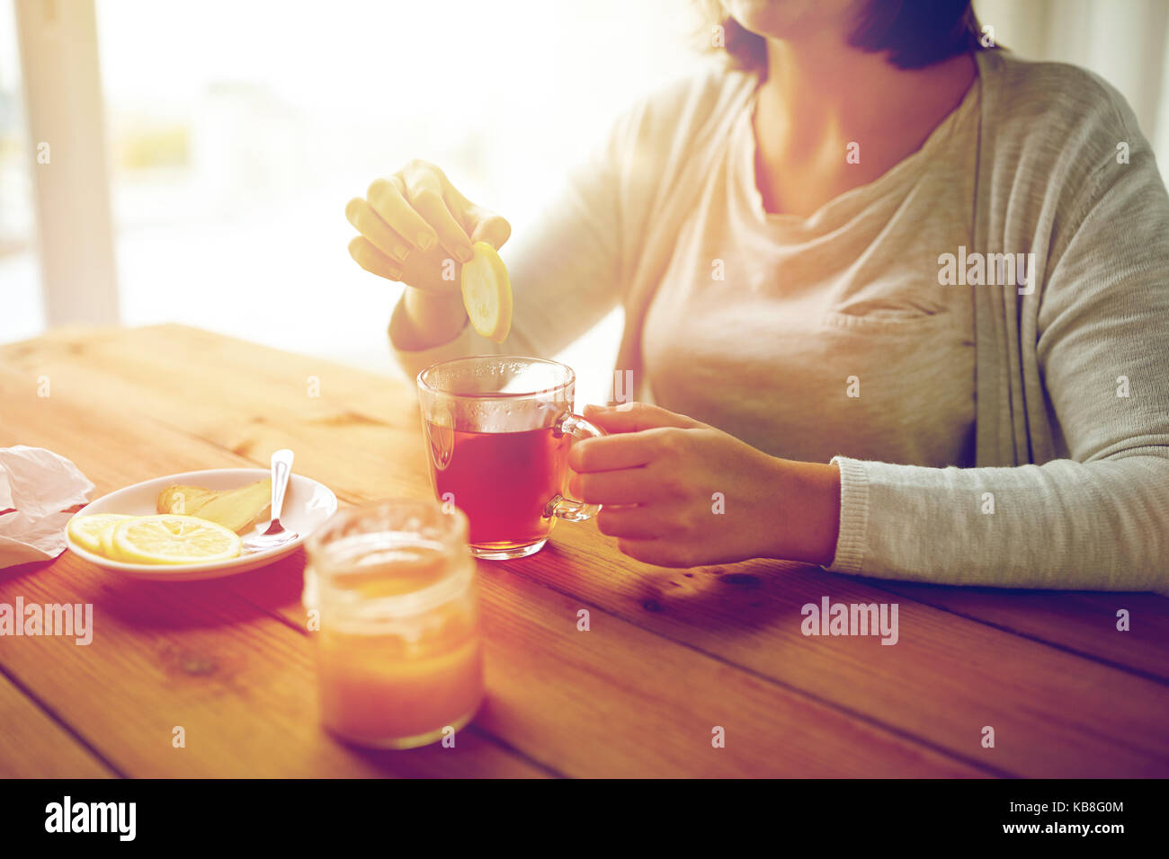 Close up of woman adding lemon to tea cup stock photo alamy
