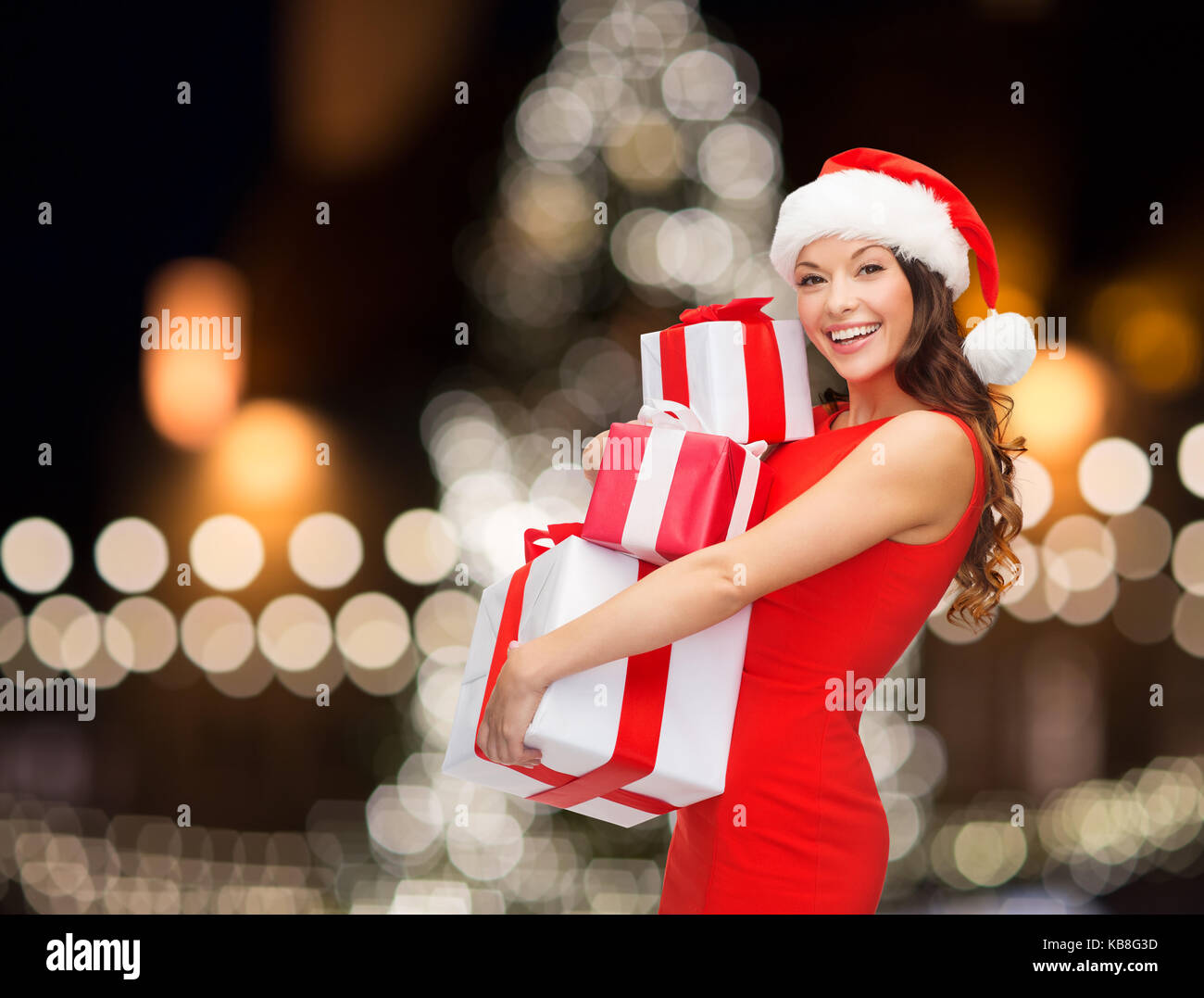 smiling woman in santa hat with gift boxes Stock Photo - Alamy