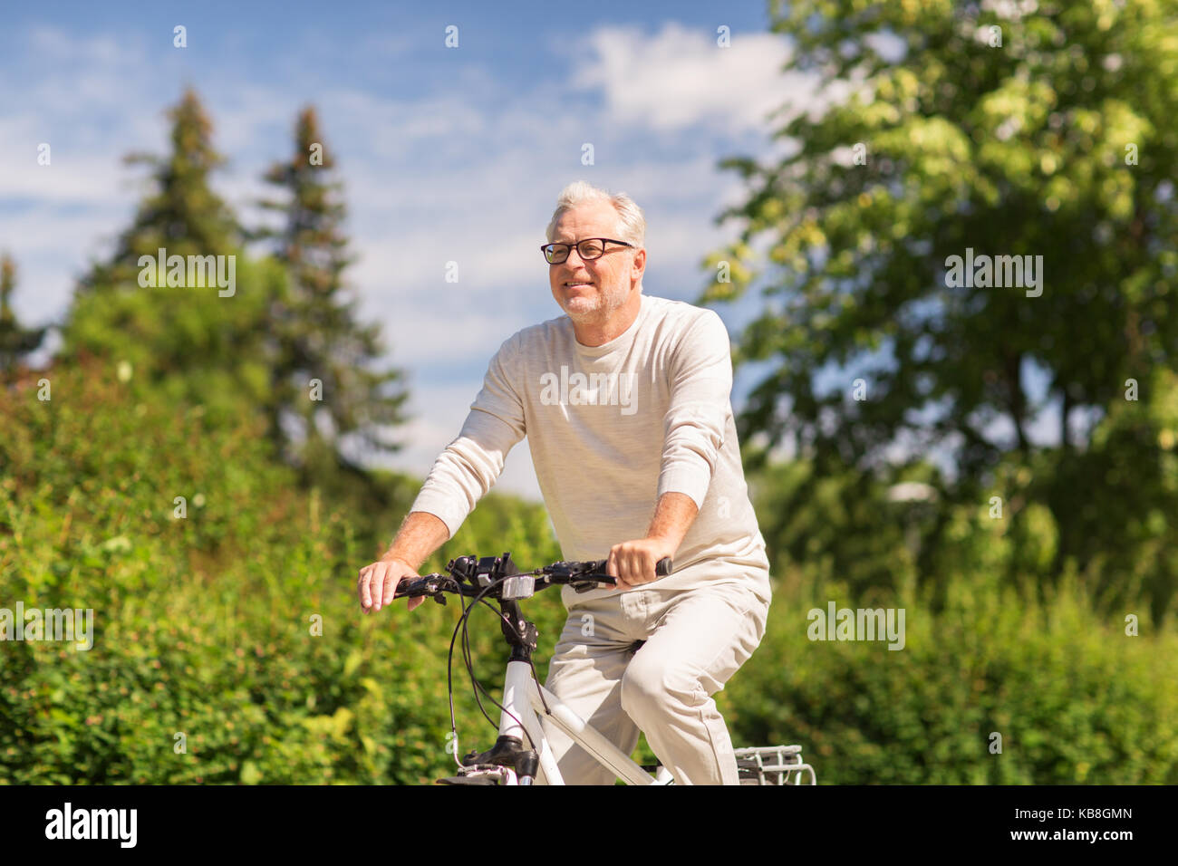 happy senior man riding bicycle at summer park Stock Photo - Alamy