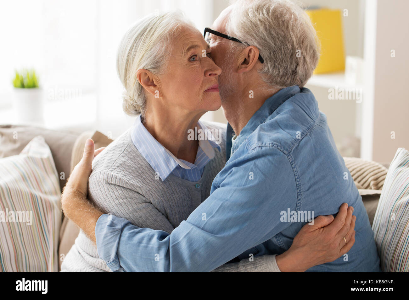 sad senior couple hugging at home Stock Photo