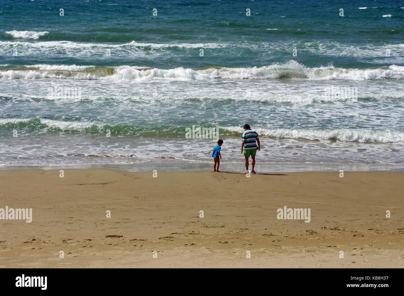 Father and son take a walk by the sea Stock Photo