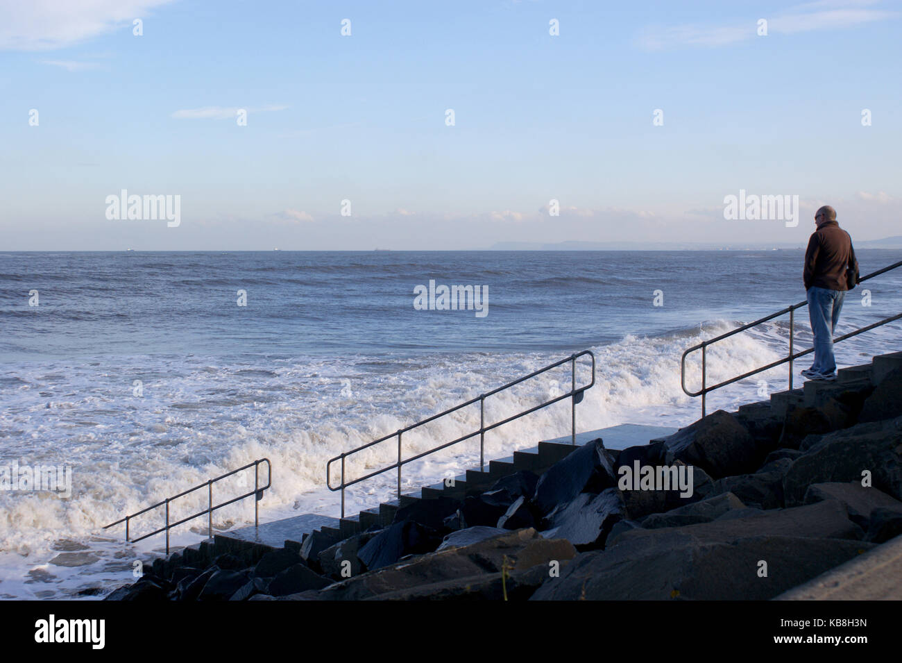 Person on Steps Leading Down To The Beach as the Tide Comes In At Seaton Carew Hartlepool Stock