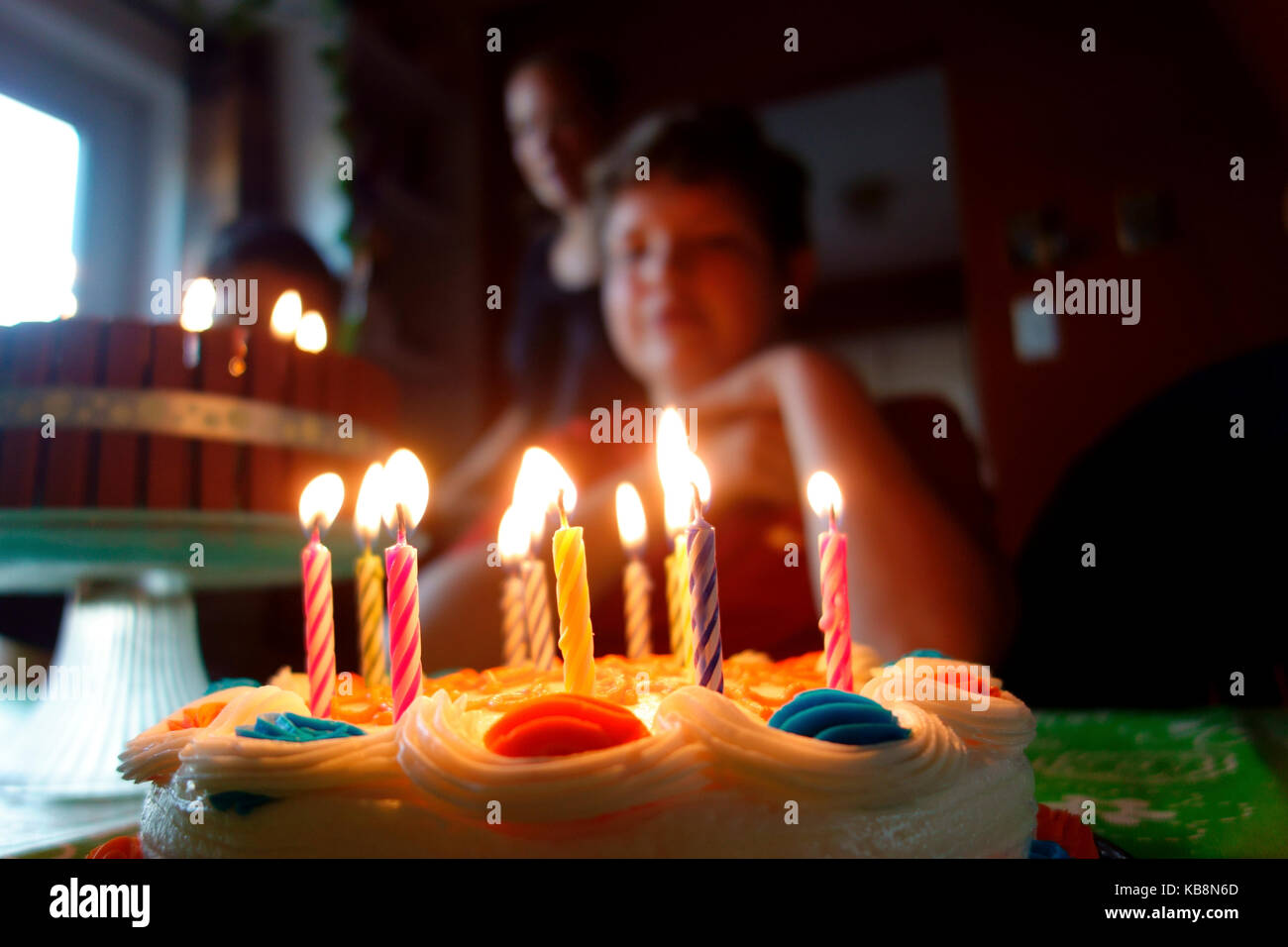 A birthday cake with lit candles in front of an 11 year old boy Stock Photo