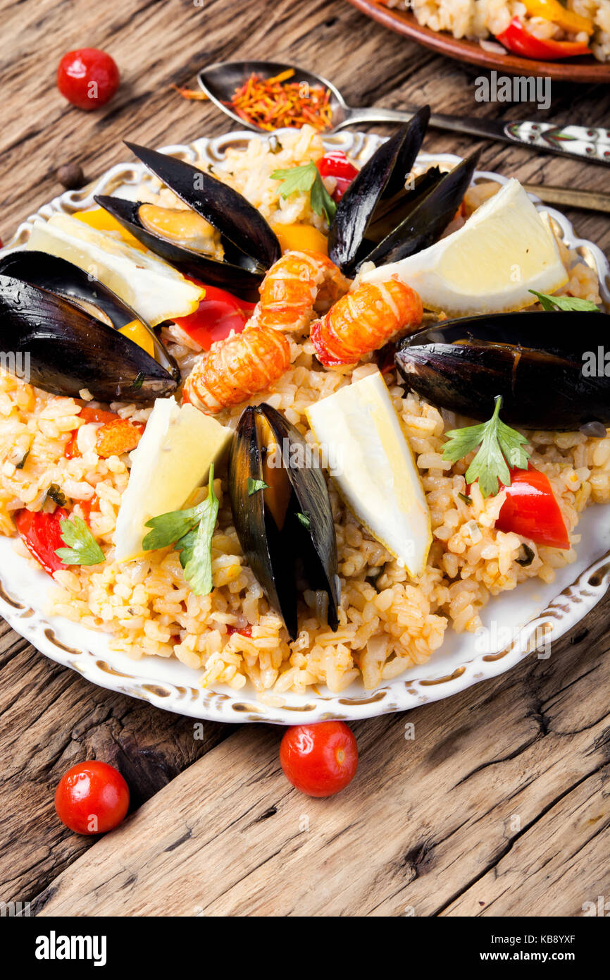 Traditional vegetable paella with seafood on wooden background Stock Photo