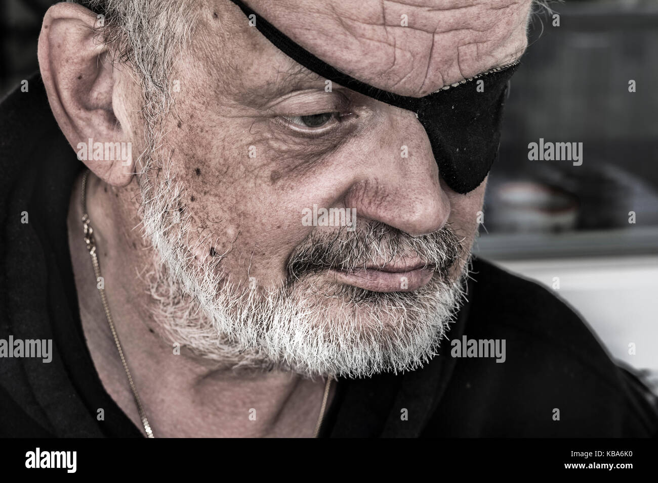 Cropped portrait of a bearded senior man with eye patches Stock Photo