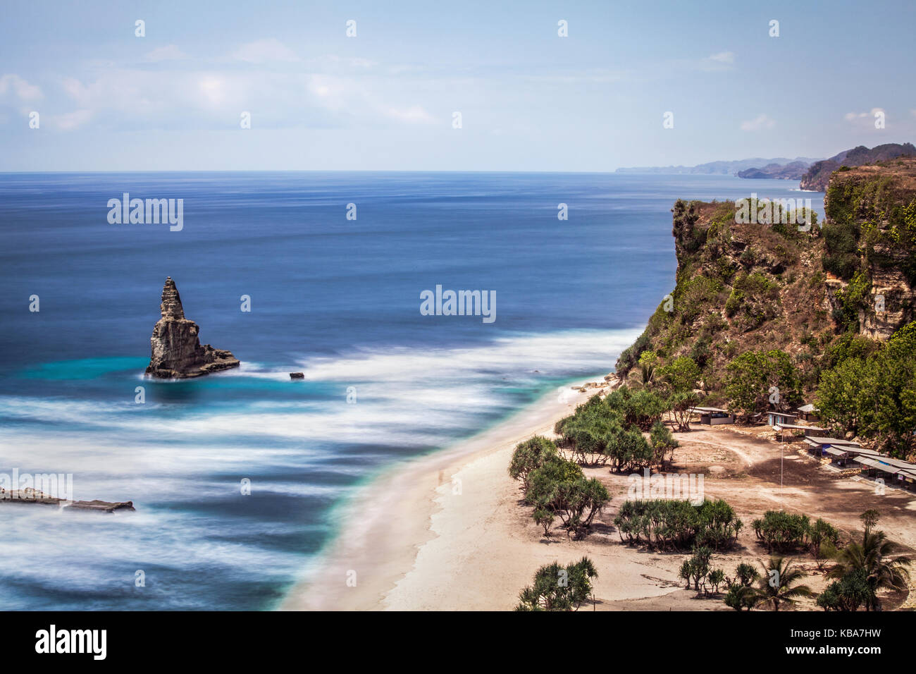 Exotic Seascape with Unique Sea Stack in the South Java Sea. Overhead view of white sand beach and surrounding cliffs with coastal rock formation Stock Photo