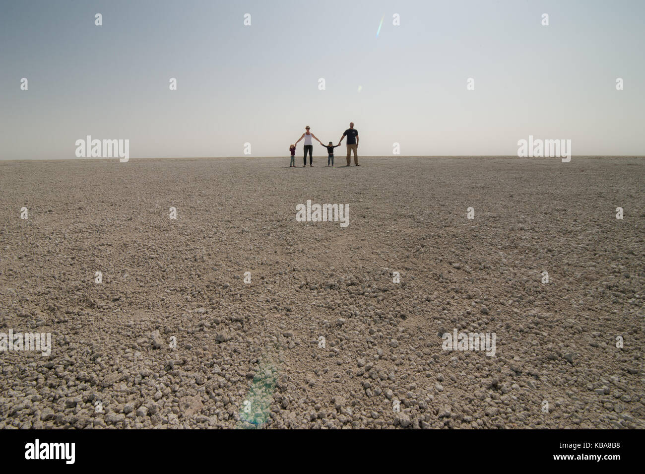 A family provides perspective for the size of the salt pan, Etosha National Park, Namibia Stock Photo