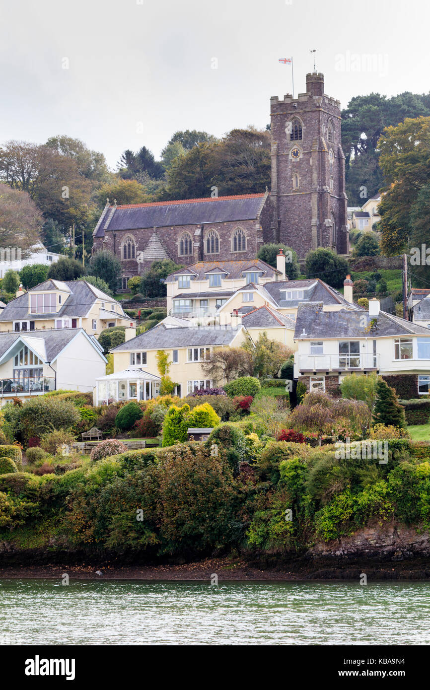 St Peter's church dominates the hillside above the tidal River Yealm at Noss Mayo, Devon, UK Stock Photo