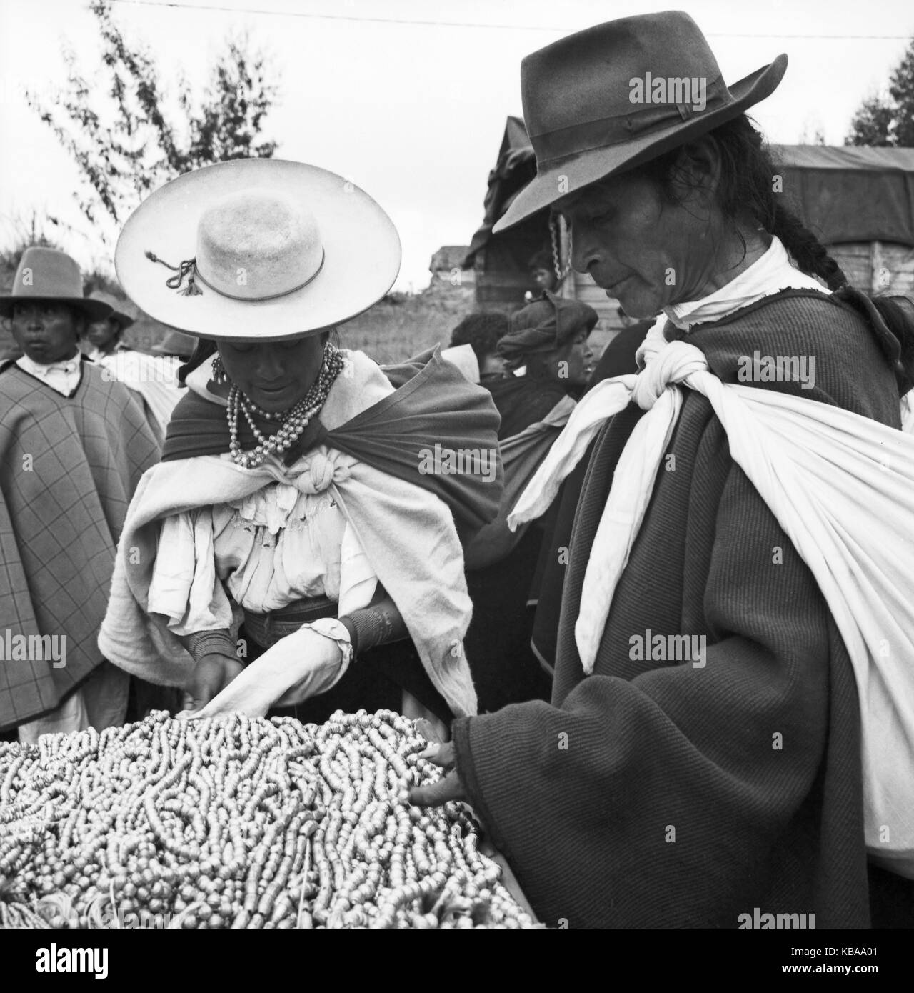 Die Kundschaft besieht sich das Angebot an Schmuckketten auf dem Markt von Otavolo, Ecuador 1960er Jahre. A couple is interested in the offer of bracelets at the market in the city of Otavolo, Ecuador 1960s. Stock Photo