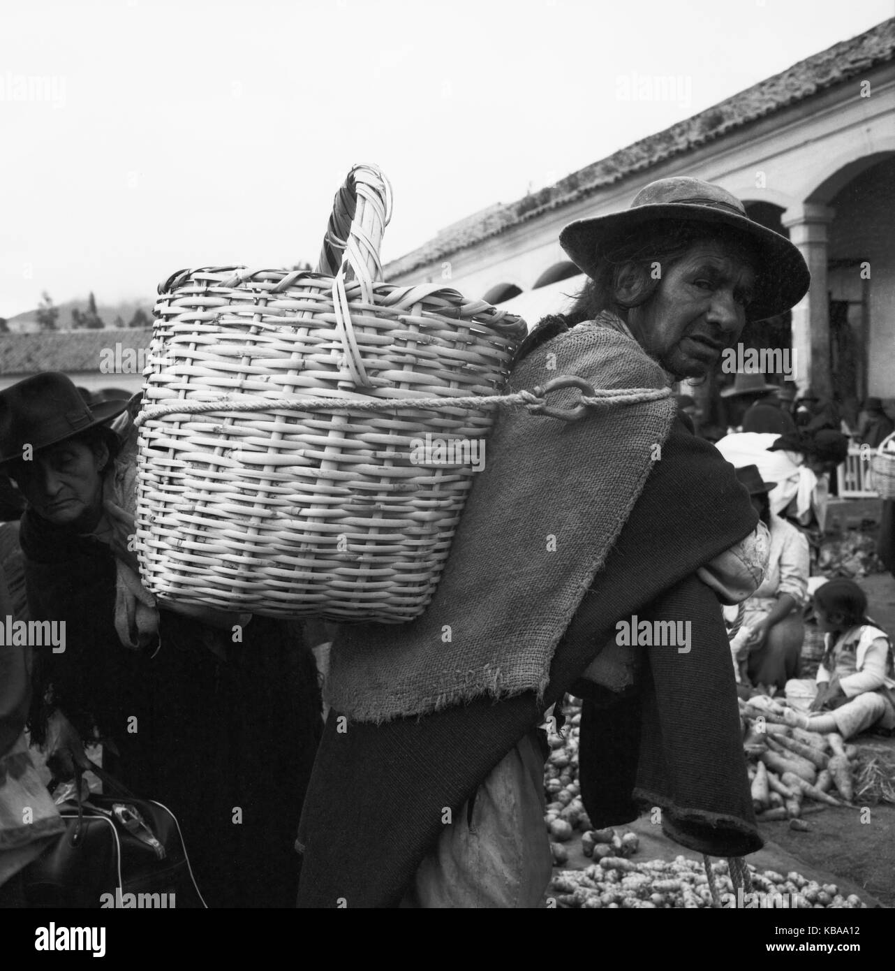 Ein Mann mit seinen Einkäufen auf dem Rücken auf dem Markt von Otavolo, Ecuador 1960er Jahre. A man with his backpack basket at the market in the city of Otavolo, Ecuador 1960s. Stock Photo