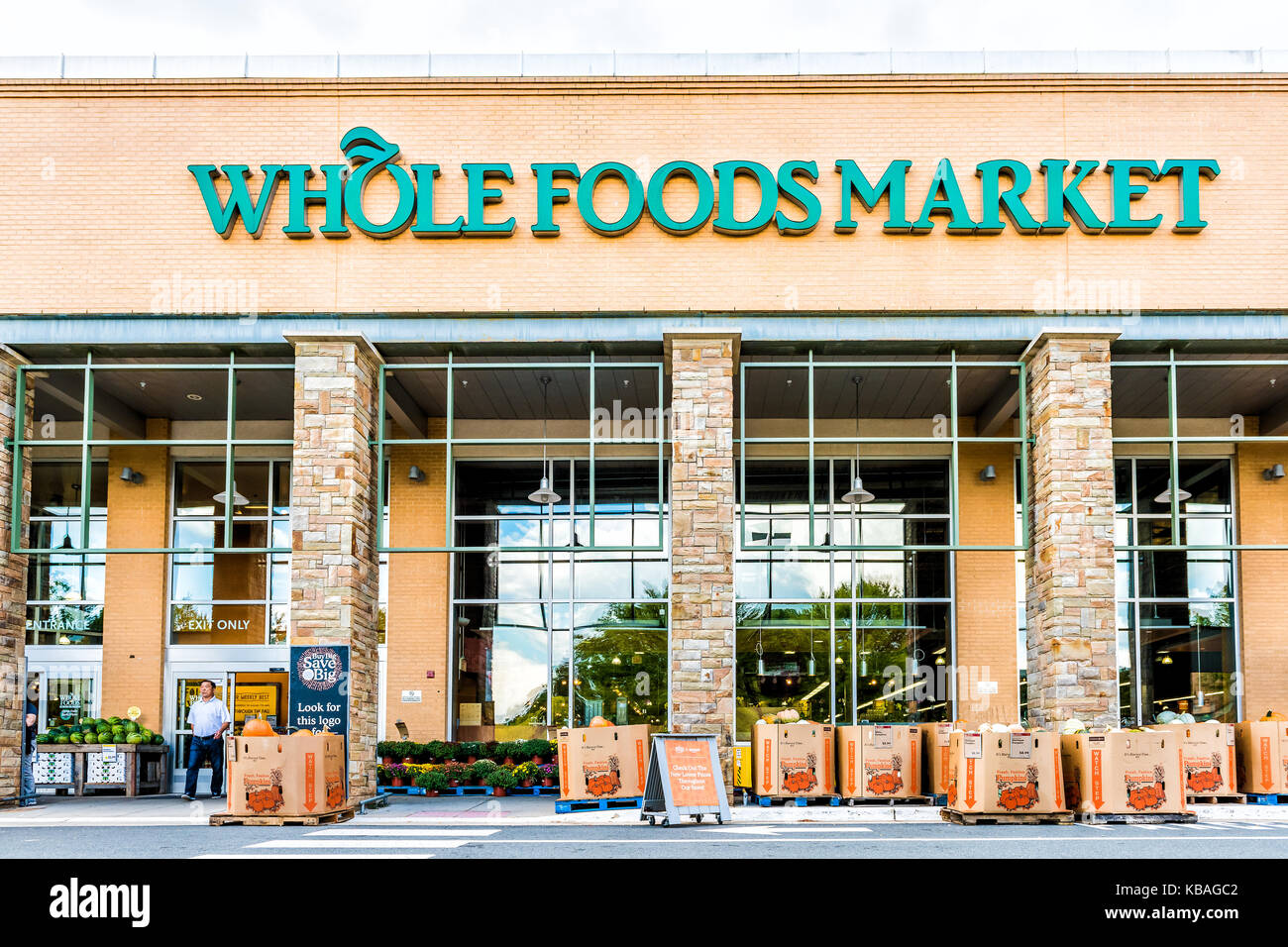 Fairfax, USA - September 8, 2017: Green Whole Foods Market grocery store sign on exterior building in city in Virginia with people walking and autumn  Stock Photo