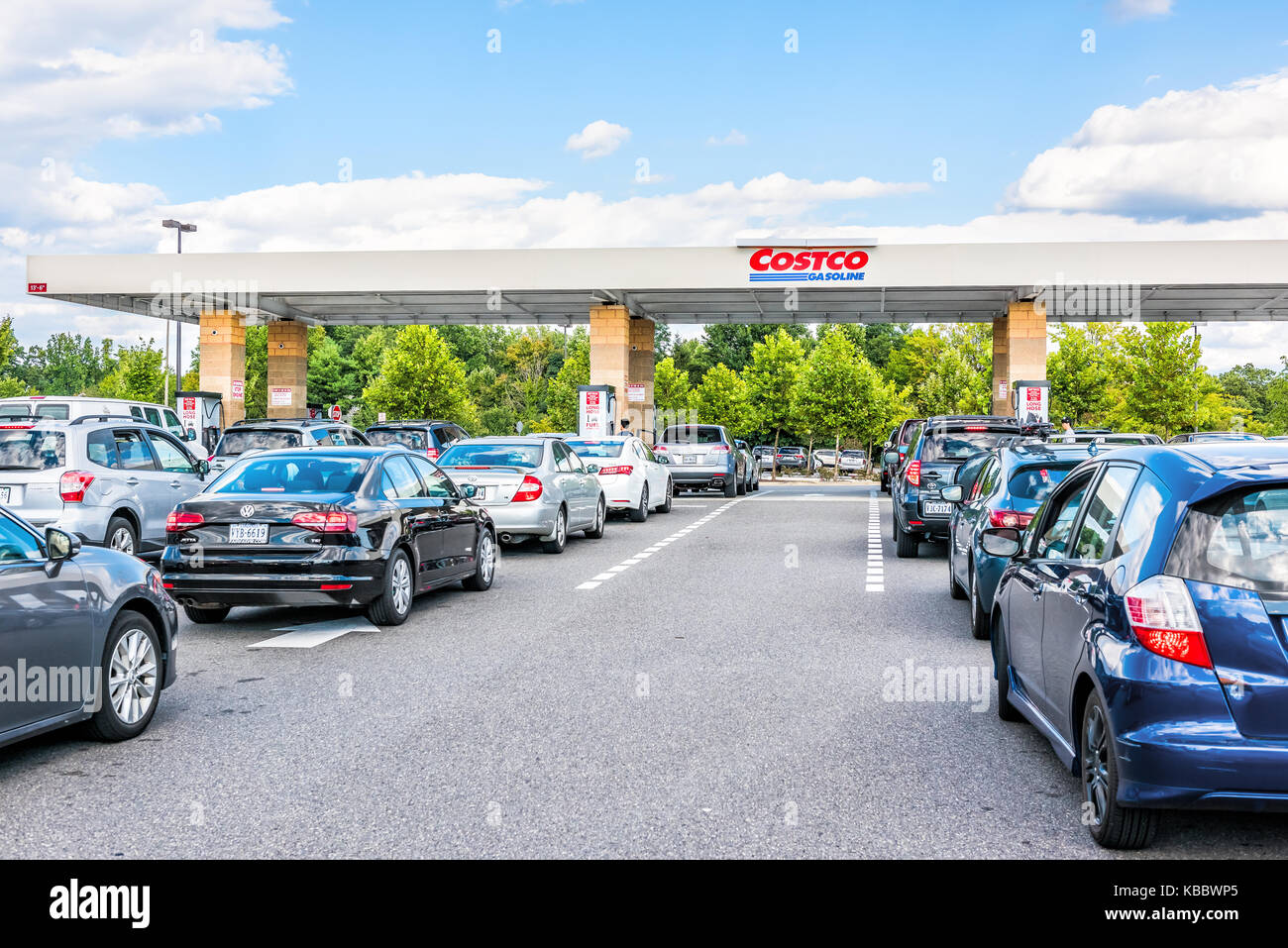 Fairfax, USA - September 8, 2017: People in cars waiting in long line queue lanes to fill up vehicles with gas, gasoline, petroleum at Costco store in Stock Photo