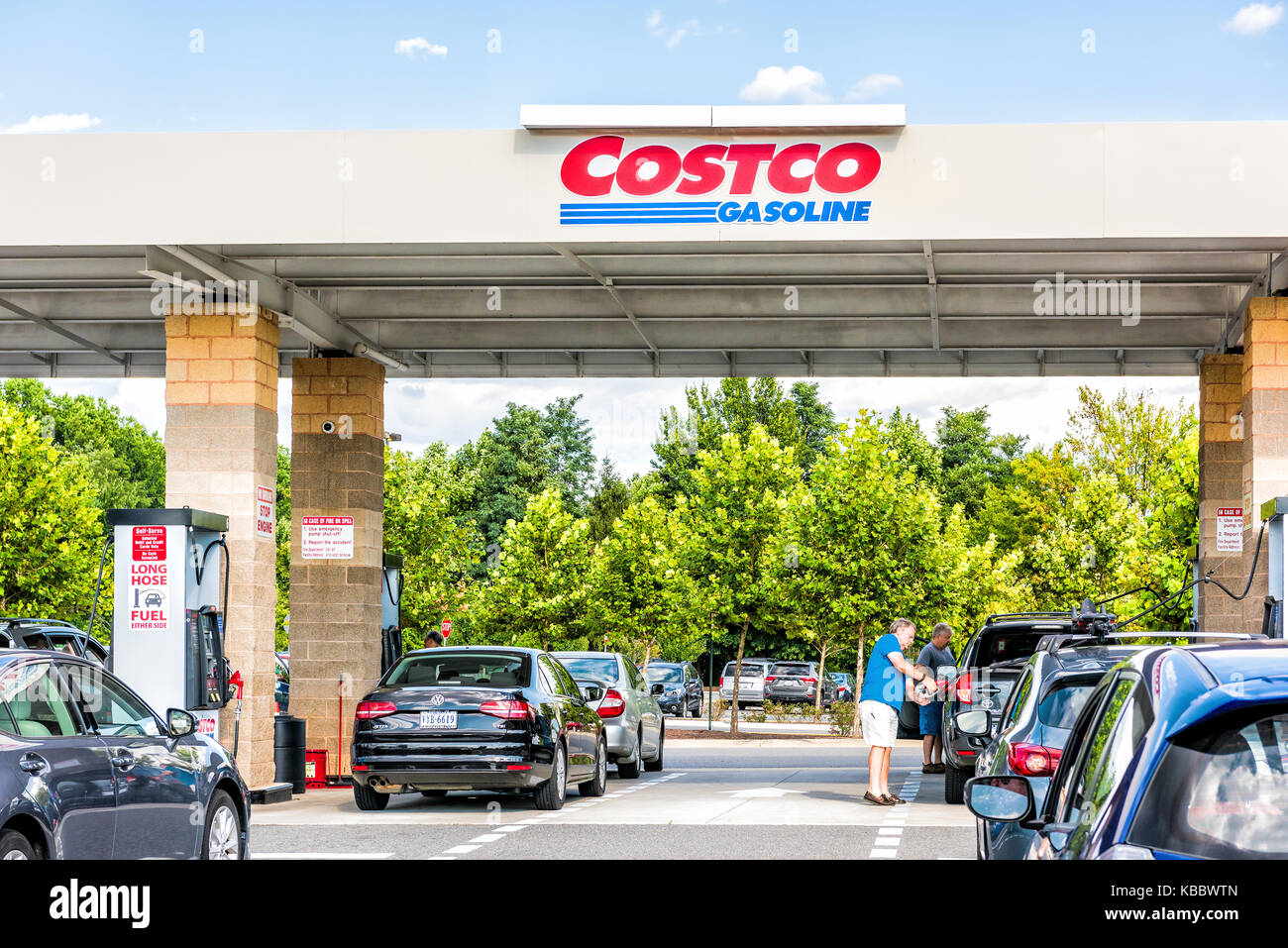 Fairfax, USA - September 8, 2017: People in cars waiting in long line queue lanes to fill up vehicles with gas, gasoline, petroleum at Costco store in Stock Photo