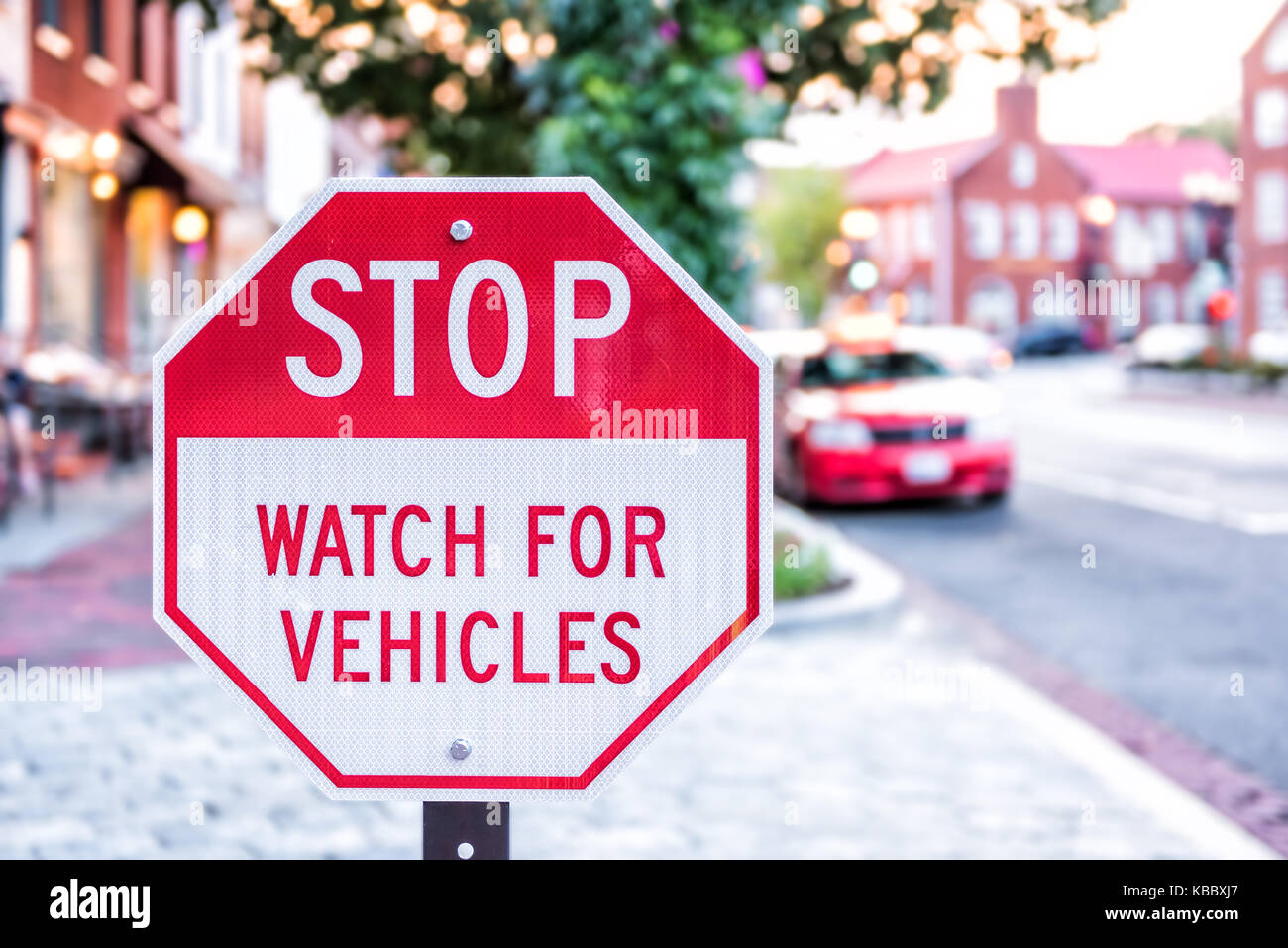 Stop Watch For Vehicles red street sign on Georgetown neighborhood of Washington DC downtown street area Stock Photo