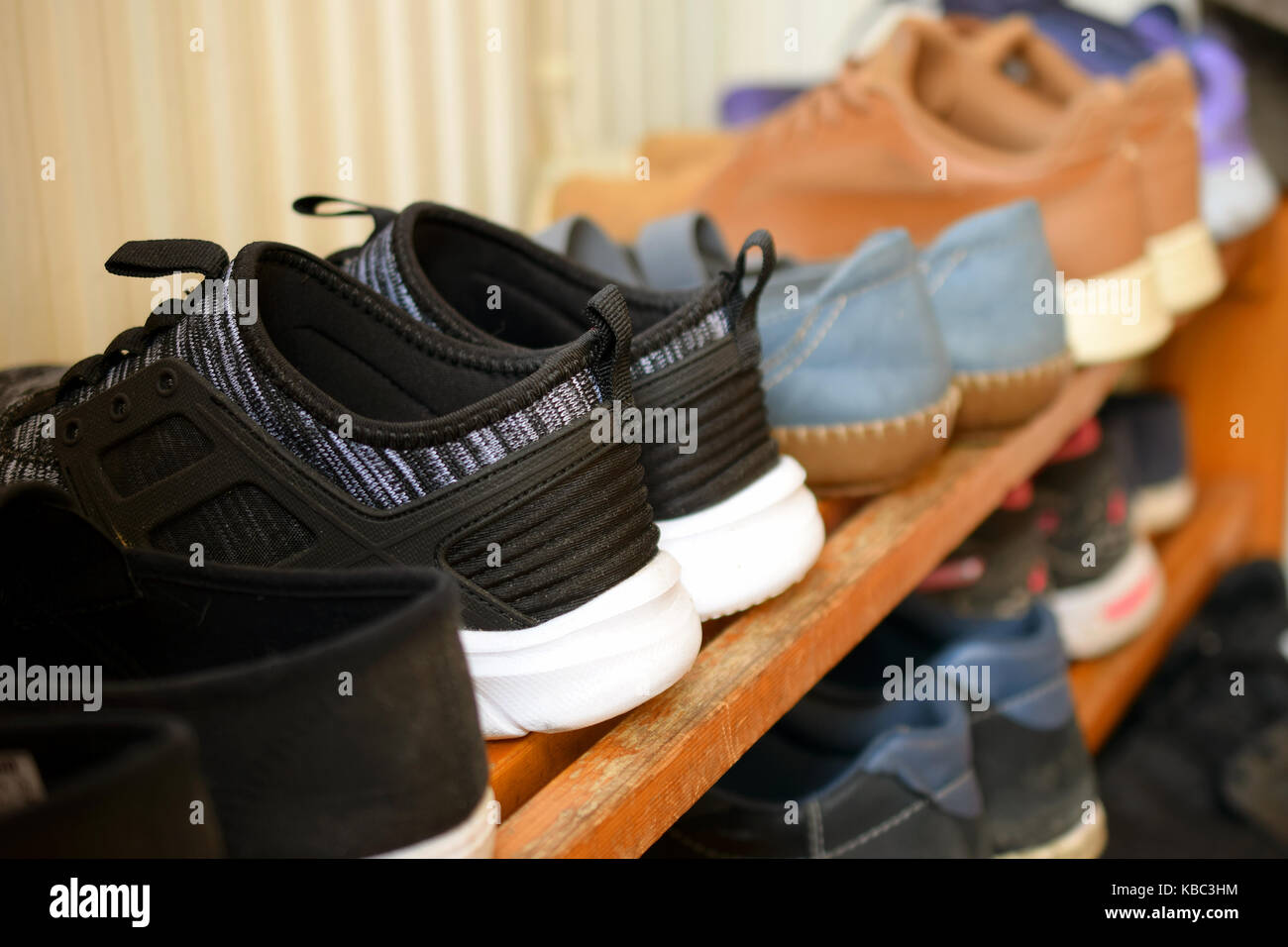 Shoes on wooden shoe rack. Close up side view image. Stock Photo