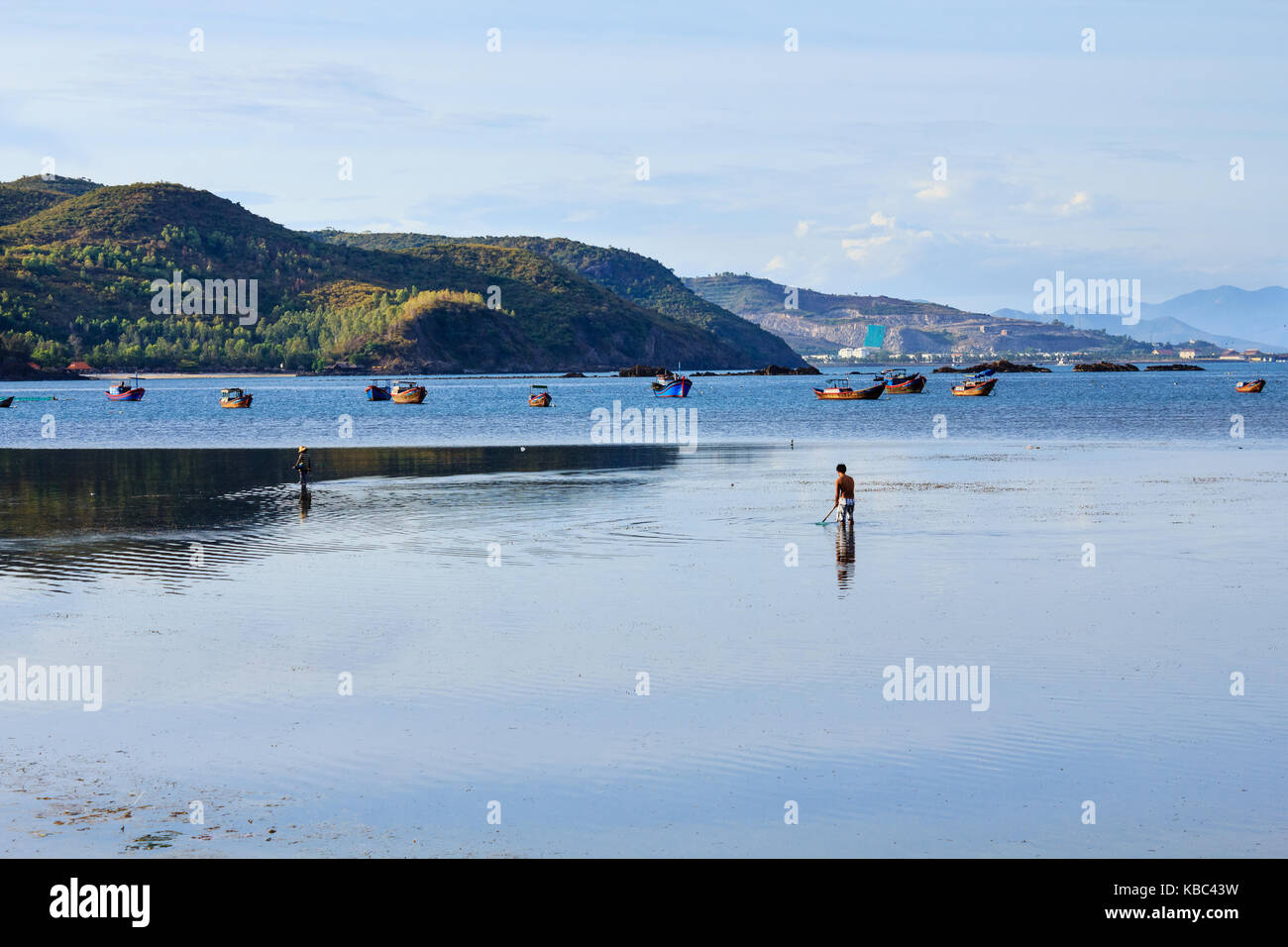 Fishermen are fishing at a lagoon on sunset in Song Lo, Phuoc Dong, Nha Trang, Vietnam. Nha Trang is well known for its beaches and scuba diving Stock Photo