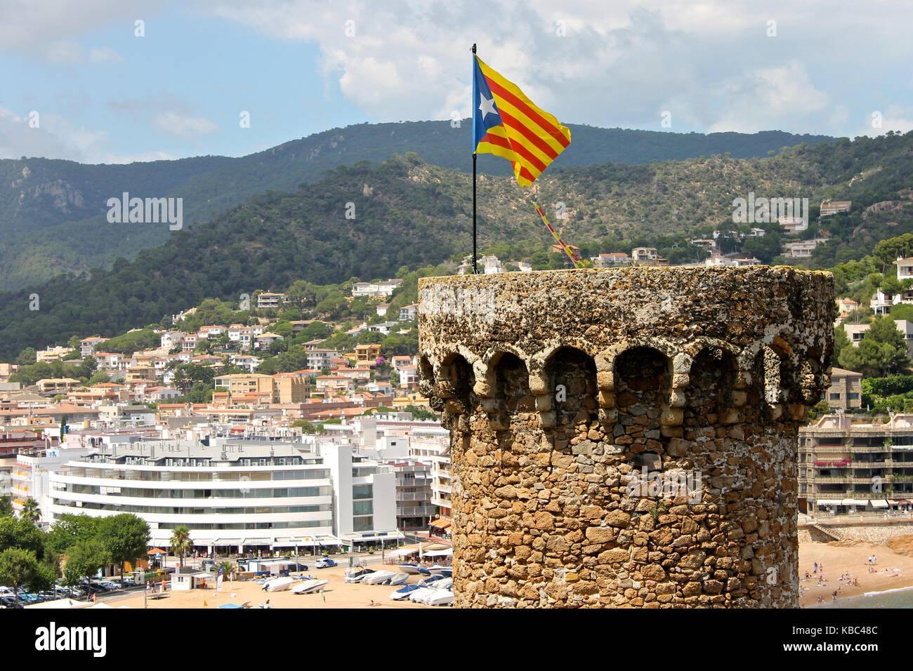 A Senyera estelada, the unofficial flag typically flown by Catalan independence supporters, waving on the tower of Tossa de Mar Fortress, Catalonia, S Stock Photo