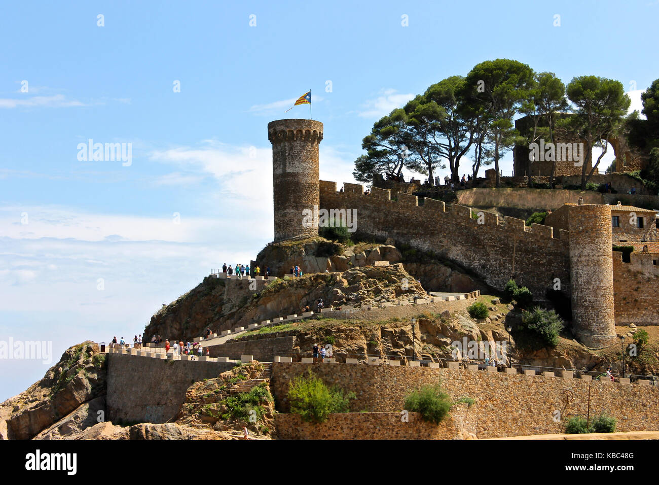 A Senyera estelada, the unofficial flag typically flown by Catalan independence supporters, waving on the tower of Tossa de Mar Fortress, Catalonia, S Stock Photo