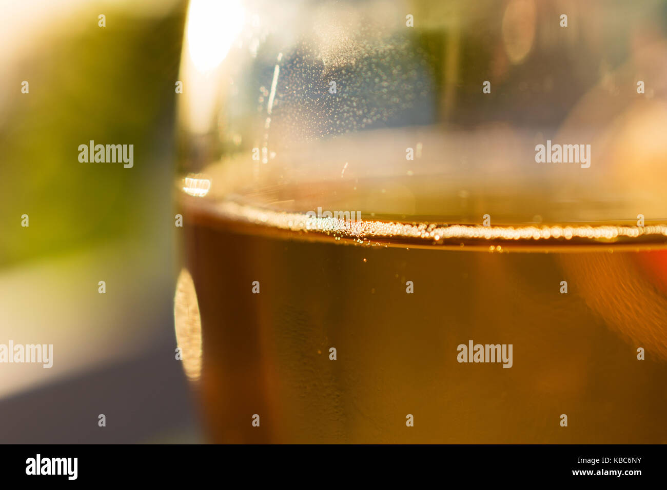 Close-Up Of Glass With Delectable Greek Retsina Wine And Tiny Bubbles During Sunset Stock Photo