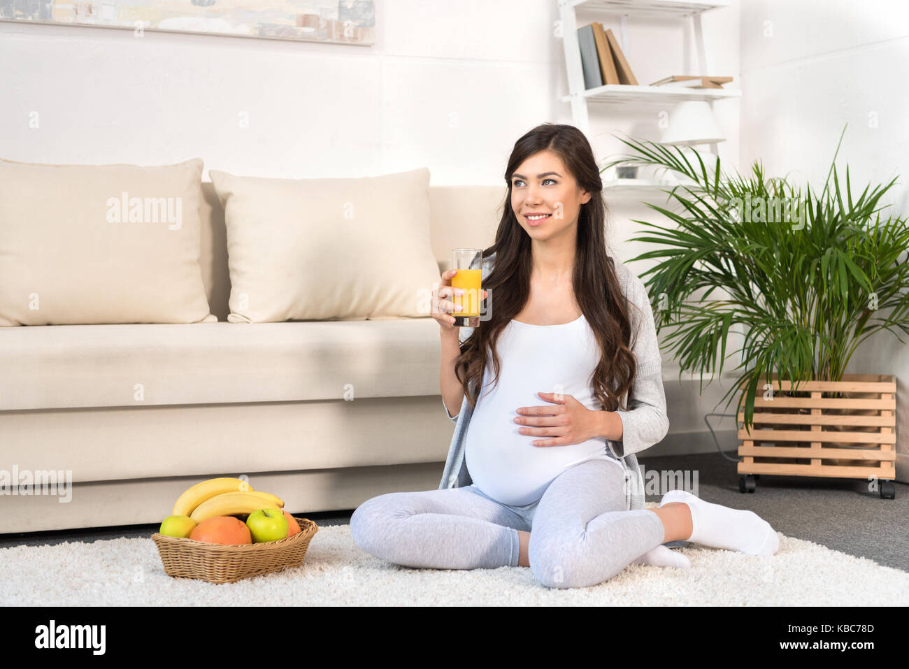 Pregnant woman holding glass of juice Stock Photo - Alamy