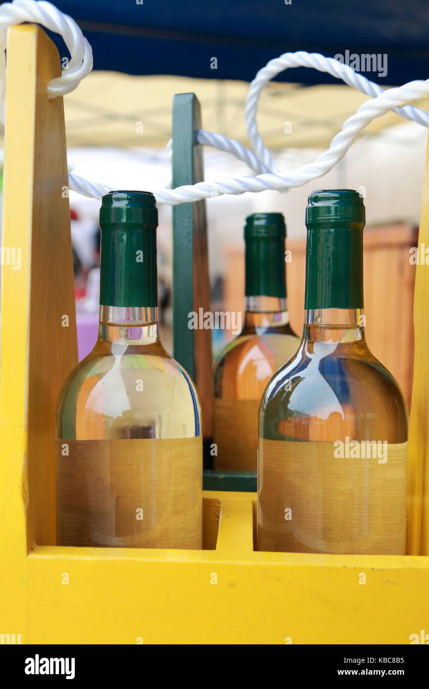 Bottles of white wine in a yellow bottle rack Stock Photo