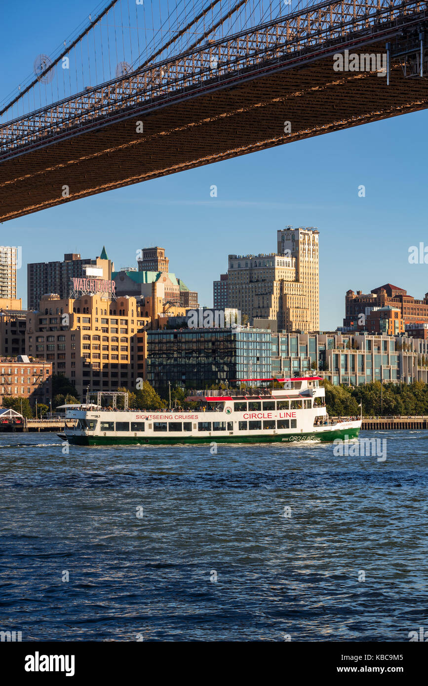 Brooklyn Bridge Park from the East River with a tourist boat. Brooklyn, New York City Stock Photo