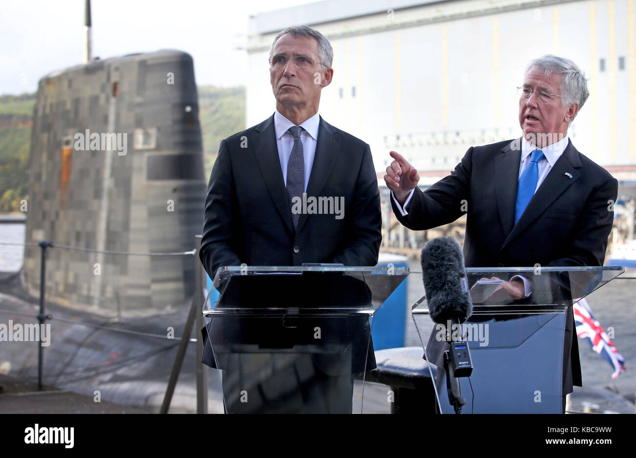 Defence Secretary Sir Michael Fallon (right) and Nato Secretary General Jens Stollenberg (left) speak to the media alongside the Vanguard-class nuclear deterrent submarine HMS Vengeance during a visit to HM Naval Base Clyde, Faslane, where bilateral talks on collective global security were held. Stock Photo