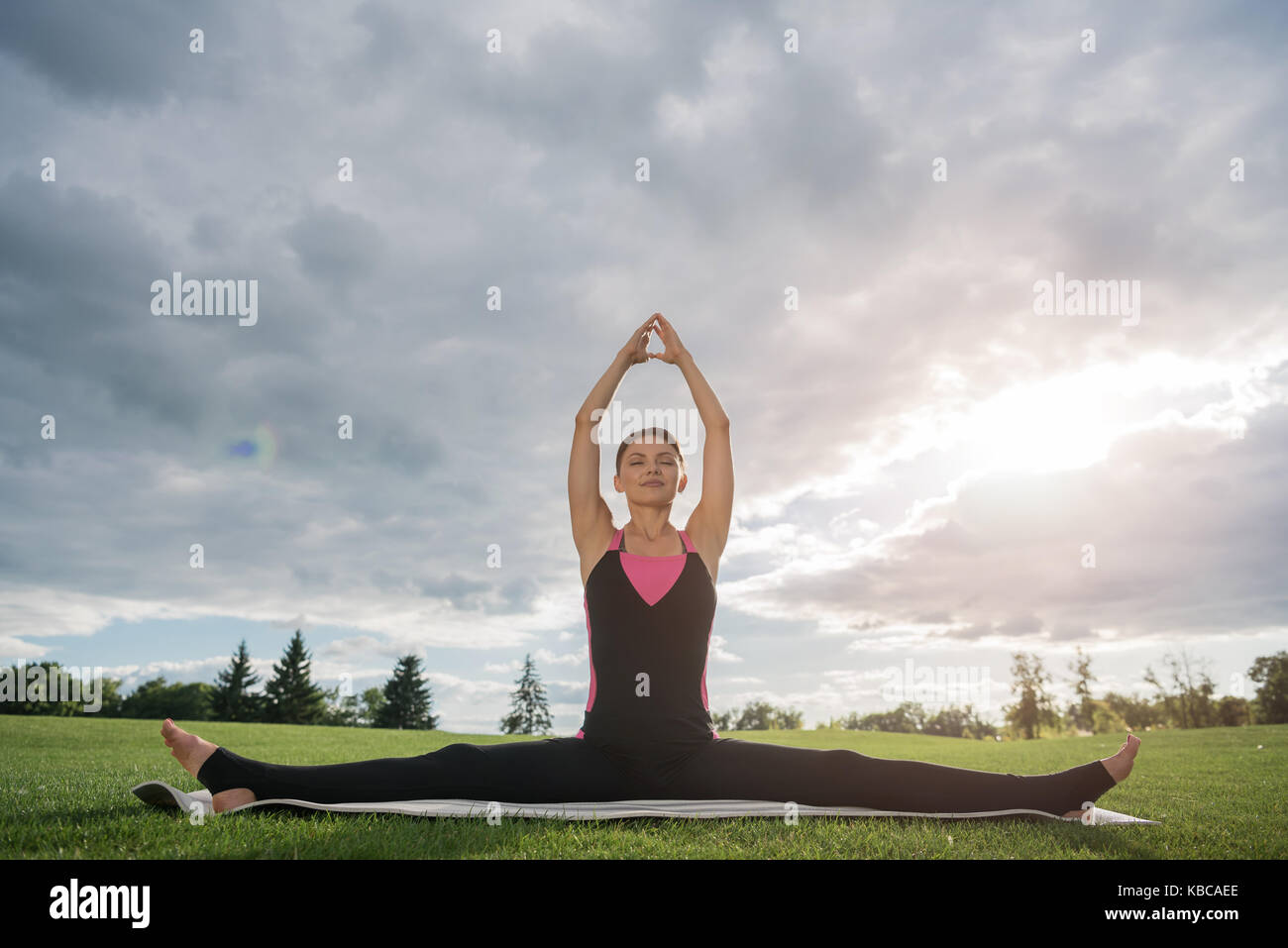 woman sitting in yoga pose in park Stock Photo - Alamy