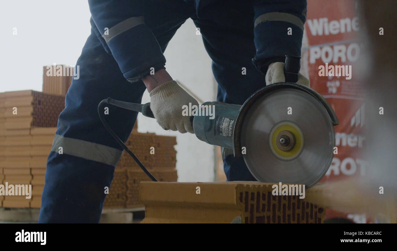Worker cutting bricks. Brick cut with circular saw or grinder Stock