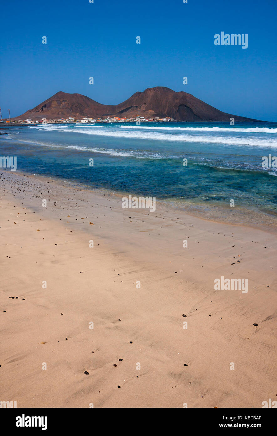 Crystal clear water and clean beach at the Atlantic ocean. Calhau town, extinct volcano crater peak in Cape Verde, Sao Vicente Island Stock Photo
