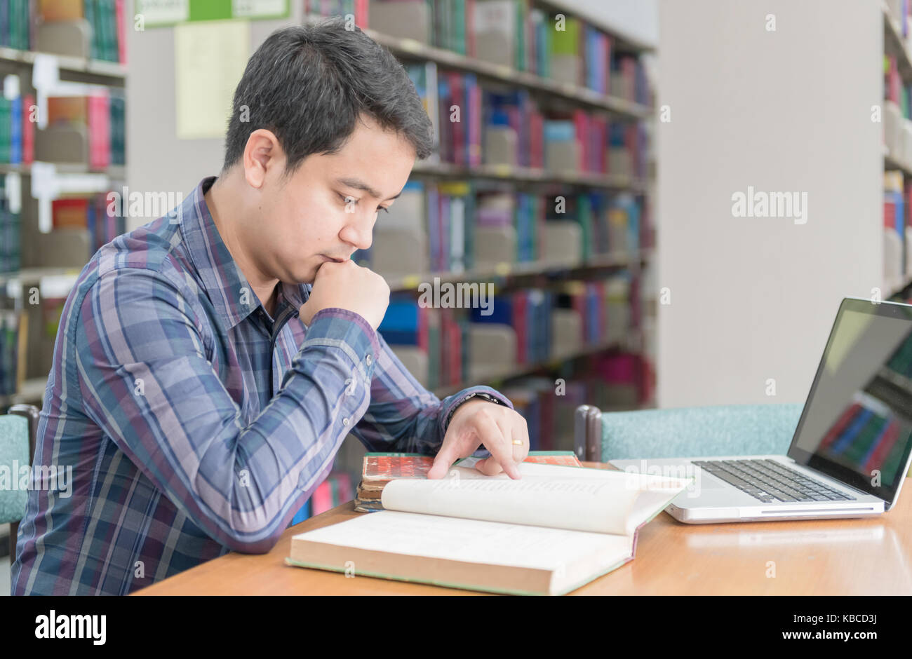 Библиотека знание людям. Компьютеры в библиотеке. Студенческие чтения. Студент читает книгу в библиотеке. Человек с книгой учета сидит за столом.