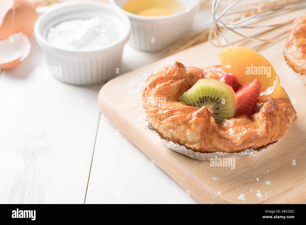 Danish bread with kiwi orange and Strawberry fruits on white wood background, bakery food Stock Photo