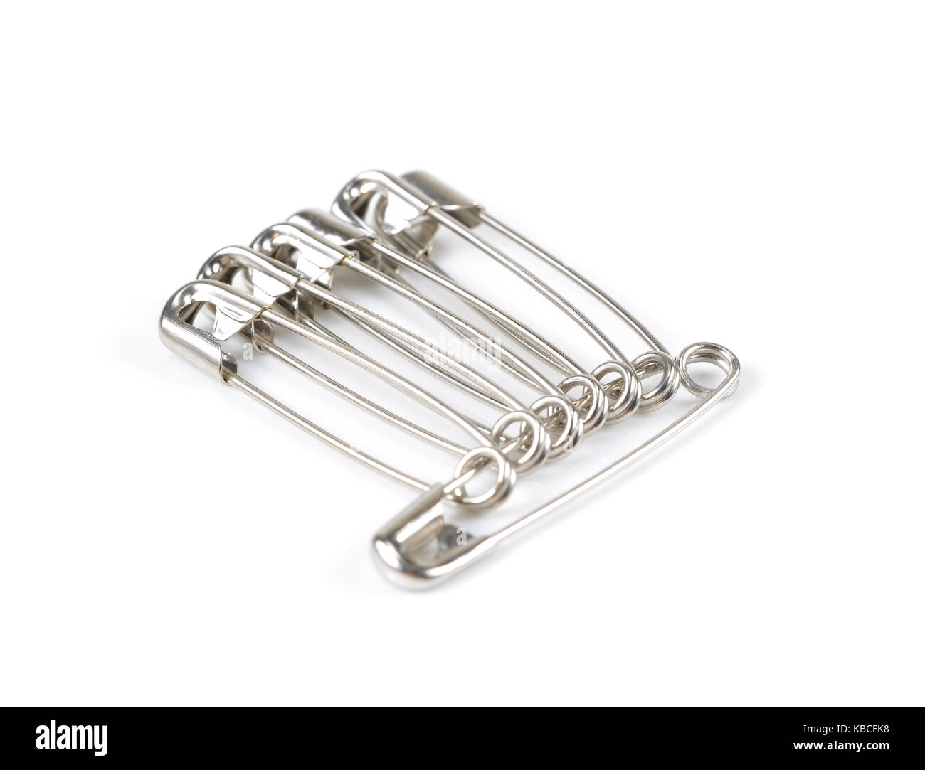 unch of safety pins on white background, shiny metal safety pin