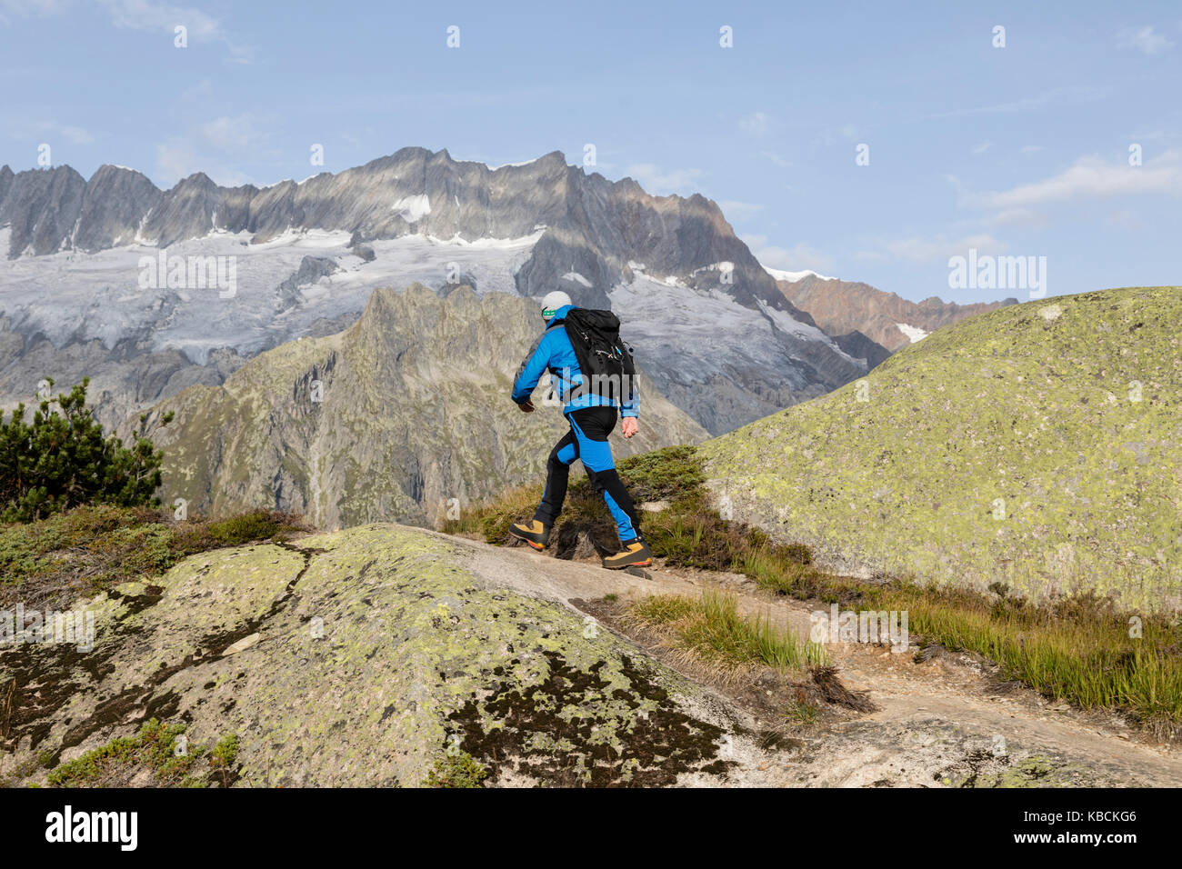 Hiker hikes through a breathtaking alpine landscape in the mountains of ...