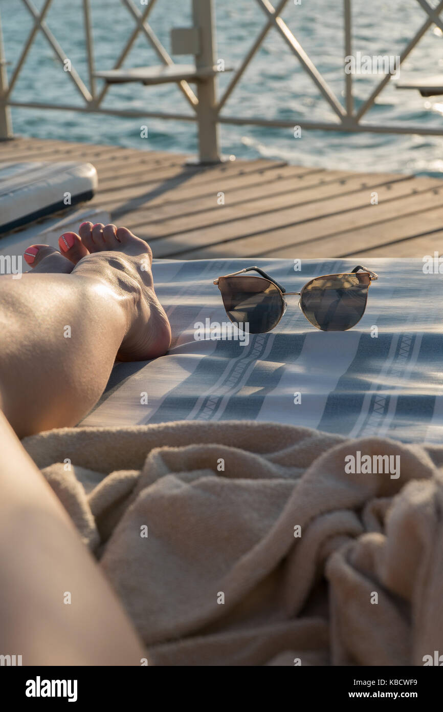 Yellow sunglasses on a lounger by the pool. Close-up. Stock Photo