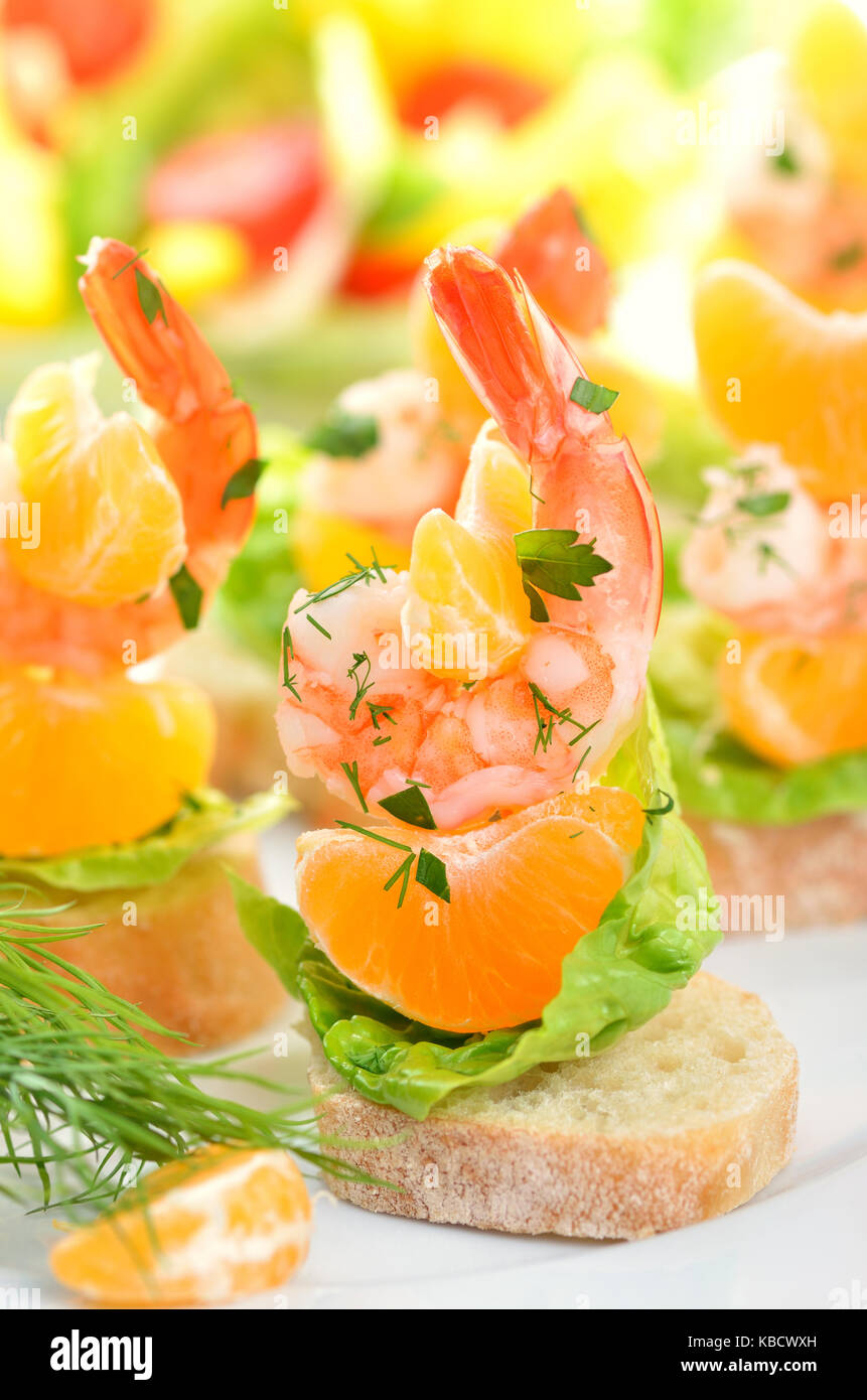 Scampi skewers with mandarin on Italian bread Stock Photo