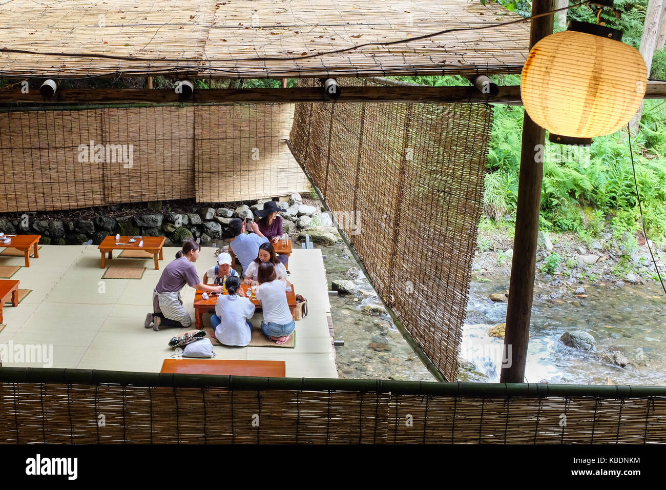 Japan Riverside Dinning Diners enjoying a meal over a river in Kibune, near Kyoto in Japan ...