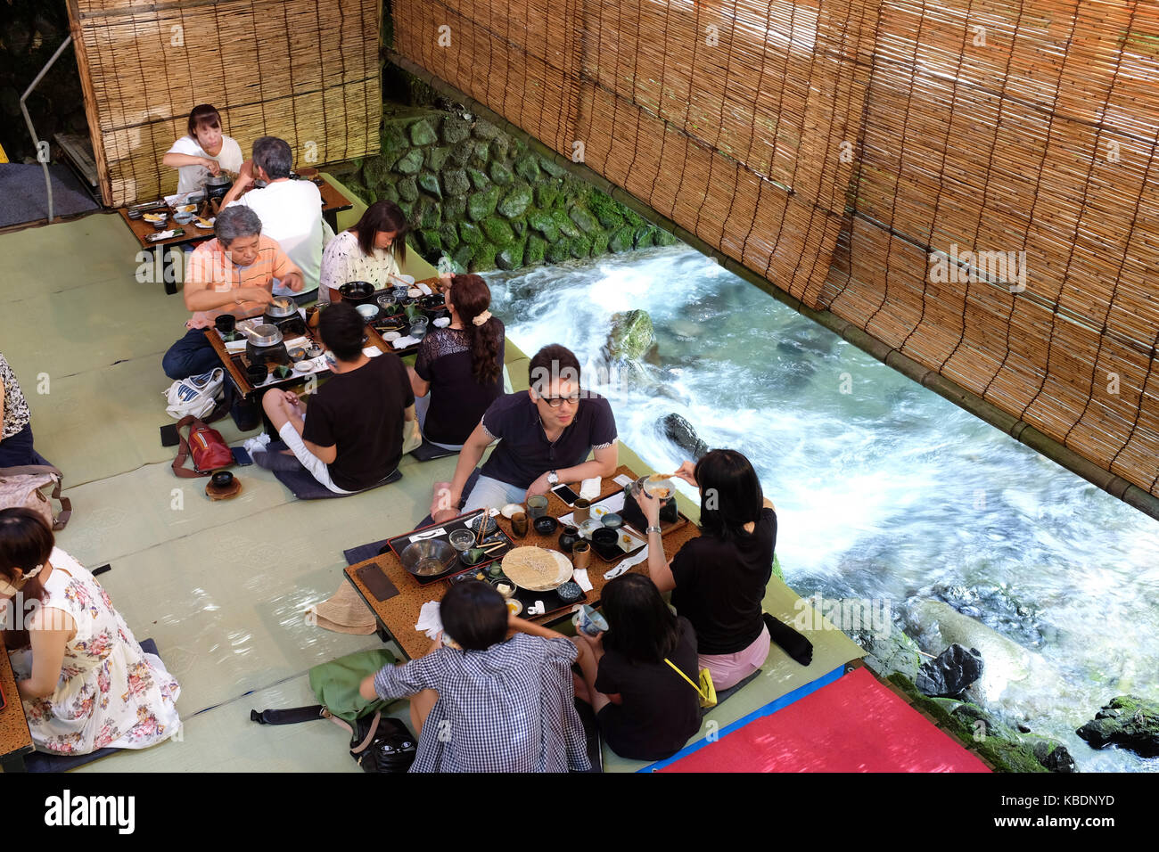 Japan Riverside Dinning Diners enjoying a meal over a river in Kibune, near Kyoto in Japan ...