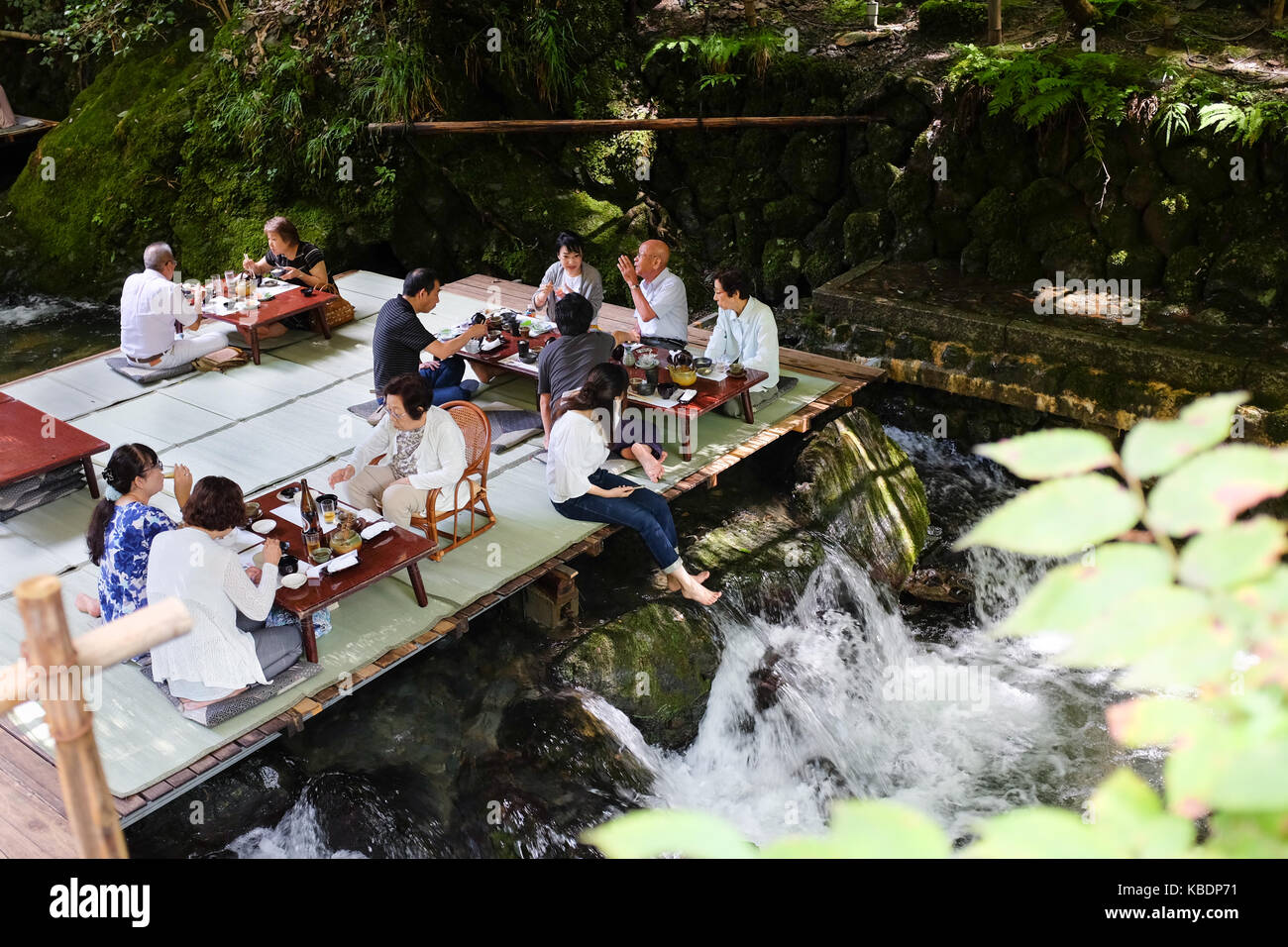 Japan Riverside Dinning Diners enjoying a meal over a river in Kibune, near Kyoto in Japan ...