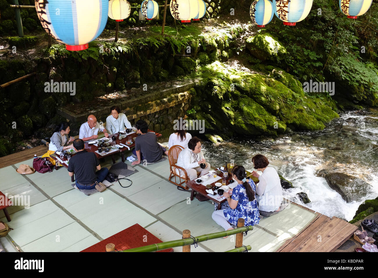 Japan Riverside Dinning Diners enjoying a meal over a river in Kibune, near Kyoto in Japan ...