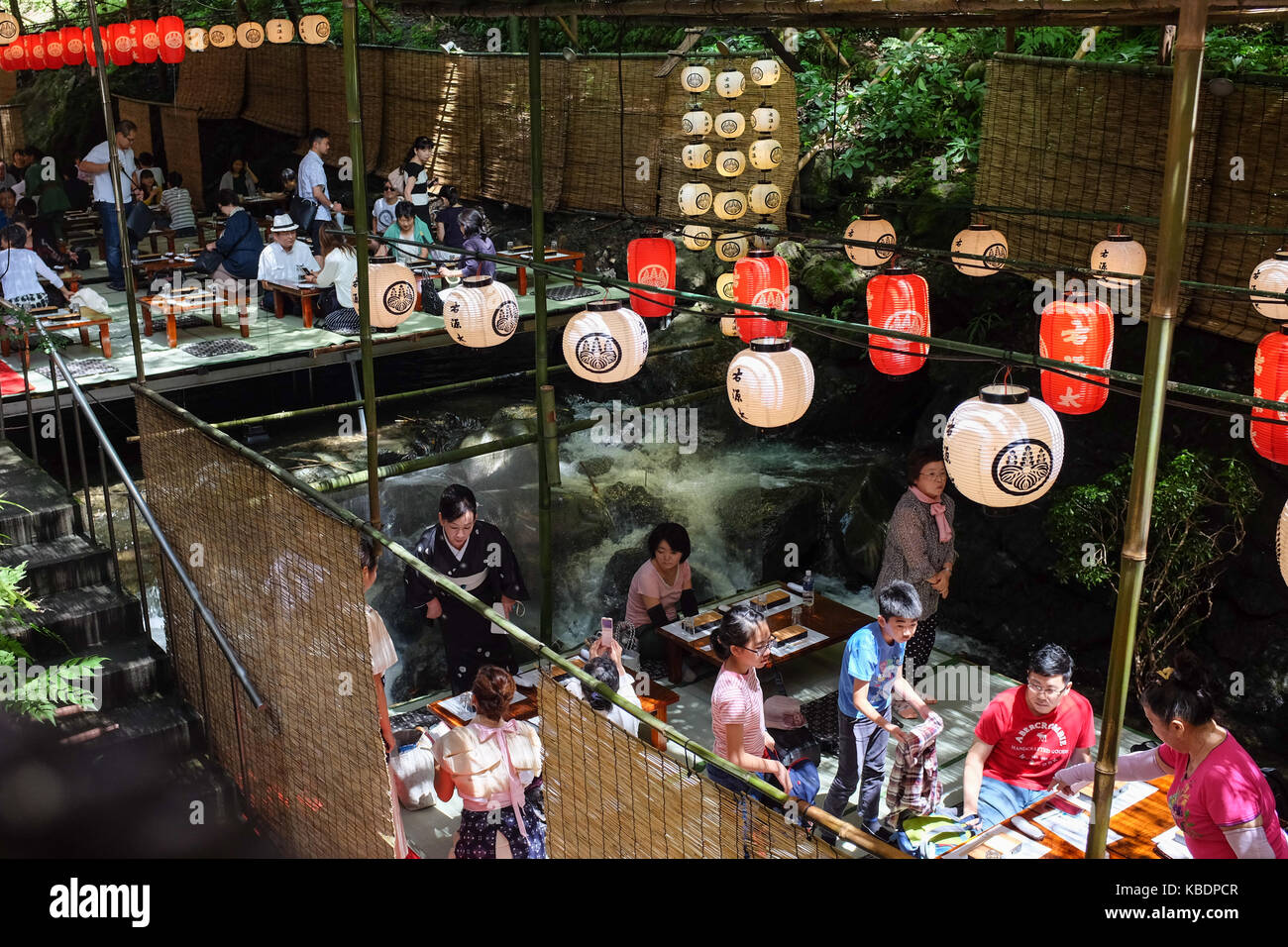 Japan Riverside Dinning Diners enjoying a meal over a river in Kibune, near Kyoto in Japan ...