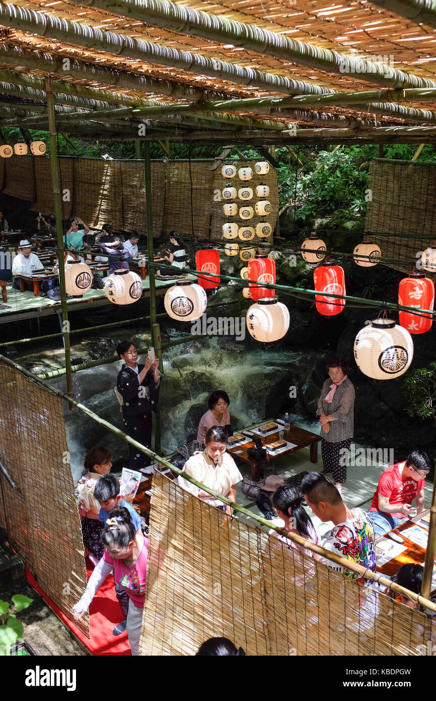 Japan Riverside Dinning Diners enjoying a meal over a river in Kibune, near Kyoto in Japan ...